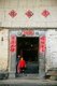 China: Children at the entrance to their square Hakka Tower (tulou) near Hukeng, Yongding County, Fujian Province